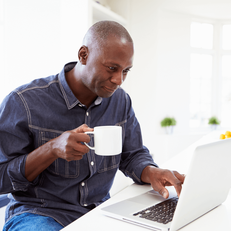 Man having coffee while on the computer